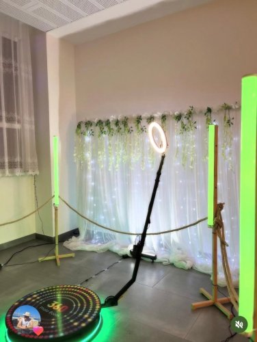 Moderná 360 Video Búdka od FunFlash pripravená na svadobnú zábavu s kruhovým svetlom a dekoratívnym pozadím so svetielkami.