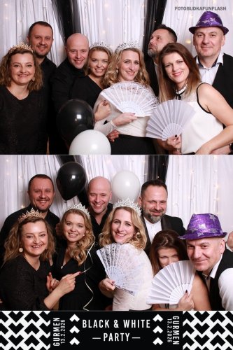 Hostia na podujatí Fotky z pár akcií sa zabávajú vo fotobúdke s rekvizitami ako vejáre, korunky a balóny počas tematickej Black & White Party.