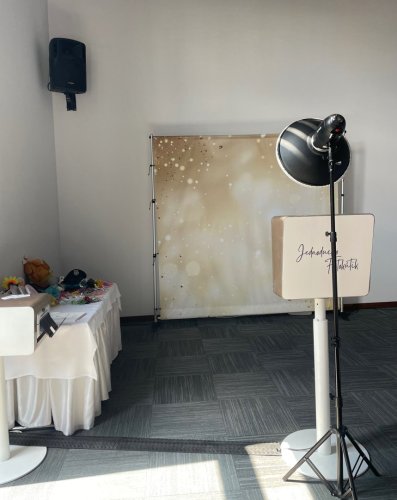 Zostava Jednoducho Fotokútik s elegantným zlato-bielym pozadím, profesionálnym osvetlením a stolom s rekvizitami na svadbu.