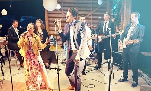 Hudobná skupina KOLOREZ band vystupuje naživo na svadobnej oslave s dvoma spevákmi a gitaristami.