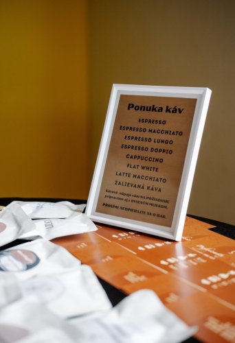 Nápojový lístok mobilného kávového baru v bielom ráme s ponukou káv ako espresso, cappuccino a latte macchiato.