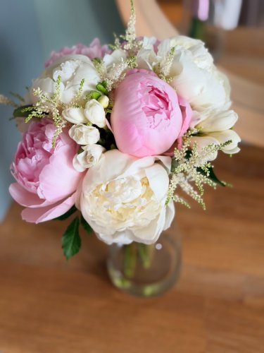 Bohatá svadobná kytica z ružových a bielych pivoniek od Alice Flowers, doplnená o jemnú astilbu a frézie.