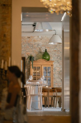 Štýlový interiér reštaurácie Truffle pig v Trnave s odhalenou tehlovou stenou, drevenou vitrínou a elegantným prestieraním.