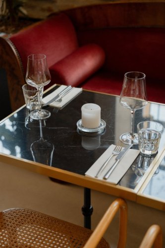 Elegantne prestretý čierny mramorový stôl so sviečkou, pohármi a príborom v prevádzke Truffle pig Trnava.